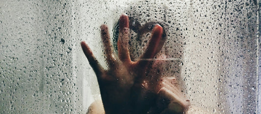 Hand reaching through glass with water droplets representing breakthrough clarity on hormone myths and cortisol stress